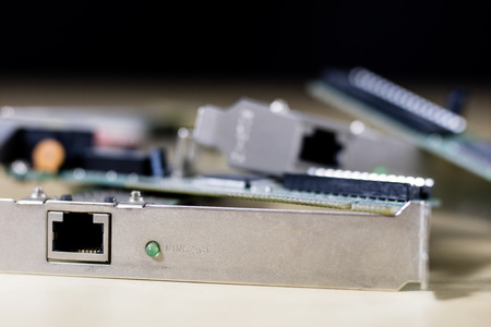 old network cards for desktop computers. Network cards with rj44 connector. Wooden table. Black...