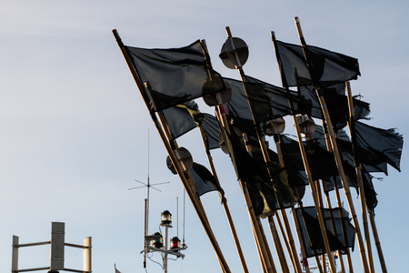 Fishing port, flags fluttering on stilts on fishing nets. Fishing nets in the port. Autumn season.の写真素材