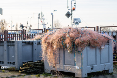 Fishing nets and ropes on a fishing boat. Fishing boats and fishing nets in a sea port. Autumn seasonの写真素材