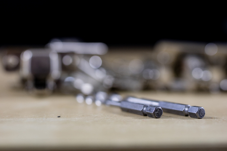 Carpentry tools and accessories on a workshop table. Hinges and screws together with the screwdriver in the workshop. Black background.の写真素材