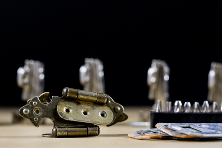 Carpentry tools and accessories on a workshop table. Hinges and screws together with the screwdriver...