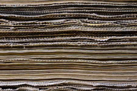 The spines of old books lying on the stack. Books stacked on an old table. Black background.の写真素材