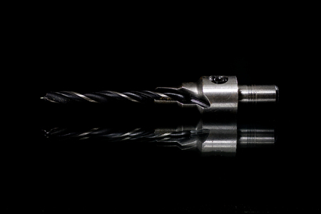 Drills with reflection in the mirror. Drills on a glass mirror table. Black background.