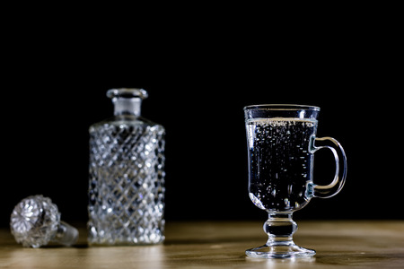 Carbonated drink in a glass bowl. Cool drink with bubbles and lemon. Black background.の写真素材