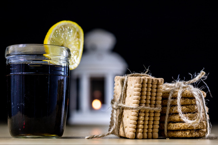 Cookies tied with a gray jute string into a bow. Cookies of sweets on a wooden kitchen table. Black background.の写真素材