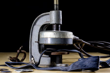 Repairing a bicycle tube in a tire bonding workshop. Detek repair station in the vulcanization workshop. Black background.の写真素材