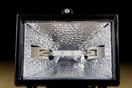 Workshop halogen lamp on a wooden workshop table. Accessories and lighting components. Black background.の写真素材