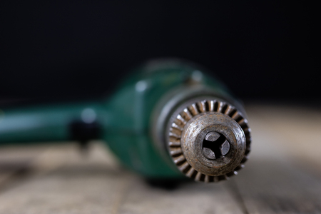 Joinery tools in a workshop. Drill, hammer and other tools on a wooden workshop table. Black...