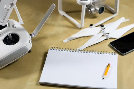 Ship flying and accessories on a wooden table. Drone notebook and accessories arranged on the examination stand. Black background.の写真素材