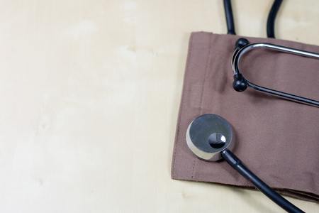 Medical accessories on a wooden table. Stethoscope, and a medical sphygmomanometer in the doctor's office. A medical journal.の写真素材