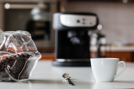 Morning coffee in the kitchen. Coffee grinder and coffee maker with coffee makers on a white kitchen table. Time of the day, morning.の写真素材