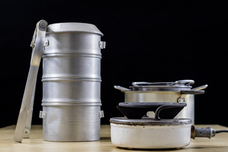 Electric razor for cooking lunch and water for tea. Old kitchen accessories on an old heater. Black background.の写真素材