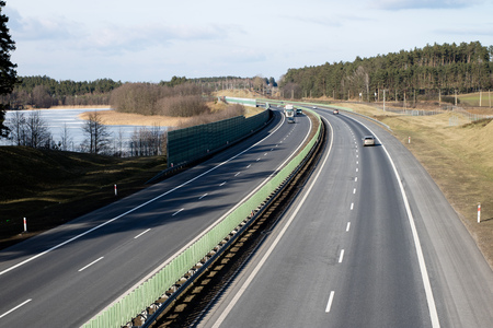 The high-speed road seen from the viaduct. Two-lane road and cars on the way. Season of the spring.