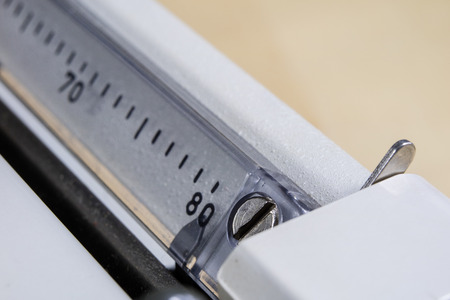 Typewriter shown in macro technology. A mechanical device for printing text. Light background.