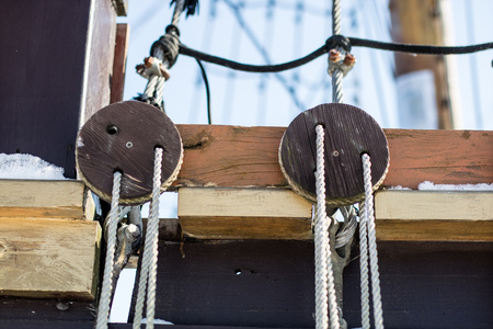 Ropes and blocks on the deck of a sailing ship and fishing boat. Rowing accessories. Winter season.