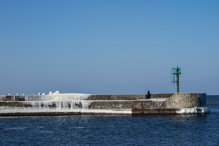 Baltic Sea in Poland. Entrance to the port, ice-covered concrete breakwater. Season winter.の写真素材