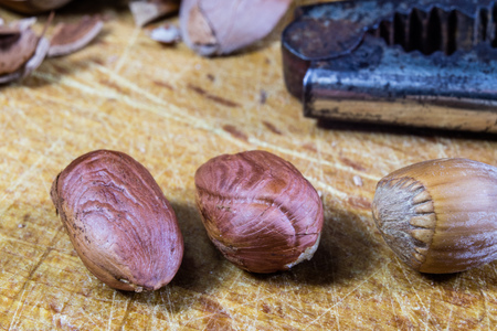 Tasty hazelnuts on a wooden kitchen table. Forest specialties and kitchen accessories. Dark background.の写真素材