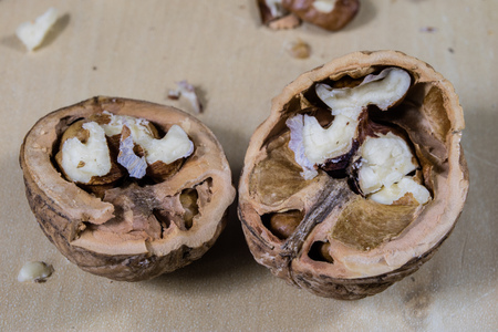 Walnuts on a wooden kitchen table. Nuts and a black wooden crate with a nutcracker. Black...