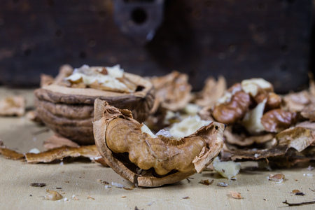 Walnuts on a wooden kitchen table. Nuts and a black wooden crate with a nutcracker. Black background.の写真素材