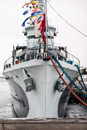 The anchor of a large warship standing in the port. Bow of a ship with an anchor on the side. Season...