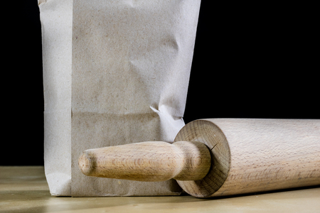 Flour and rolling pin for kneading the dough on the kitchen table. Accessories and kitchen products. Black table top.の写真素材