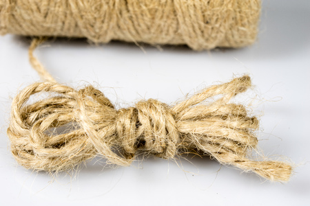 Jute twine rolled up in cradle. Accessories for packing postal parcels on an isolated background....
