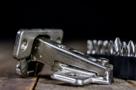 A woodwork hinge on a wooden workshop table. Joinery accessories for the construction of furniture...