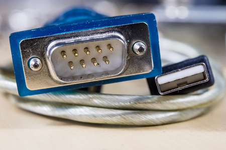COM and USB plugs on a wooden workshop table. Telecommunications connectors for building a telecommunications network. Dark background.の写真素材