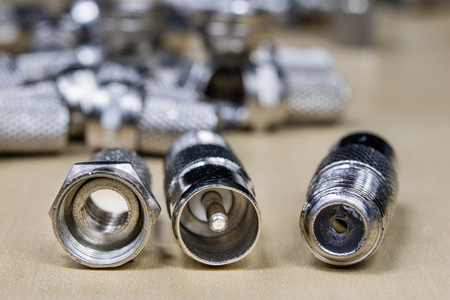 Plug type F on a wooden workshop table. Telecommunications connectors for building a telecommunications network. Dark background.の写真素材