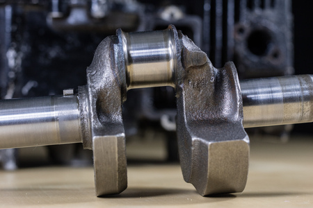 Crankshaft, piston and other parts of the internal combustion engine. Disassembled single-piston four-stroke engine on the workbench. Black background.の写真素材