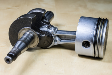 Crankshaft, piston and other parts of the internal combustion engine. Disassembled single-piston four-stroke engine on the workbench. Black background.の写真素材