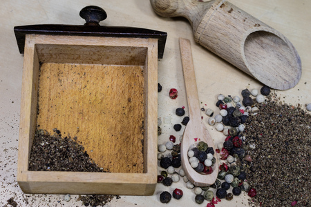 A grain of pepper on a kitchen table. Ground pepper in a kitchen mill. Culinary spices on a light background.の写真素材