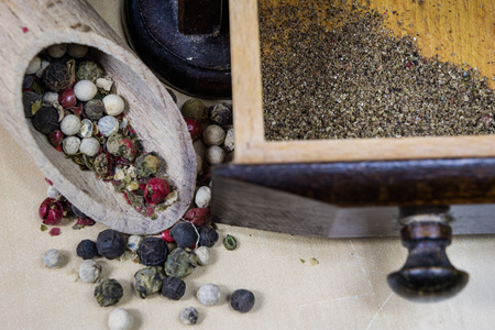 A grain of pepper on a kitchen table. Ground pepper in a kitchen mill. Culinary spices on a light background.の写真素材