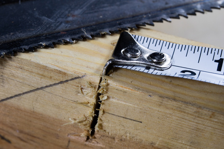 Measuring tools in a carpentry workshop. Steel measuring tape on a wooden table. Black background.の写真素材