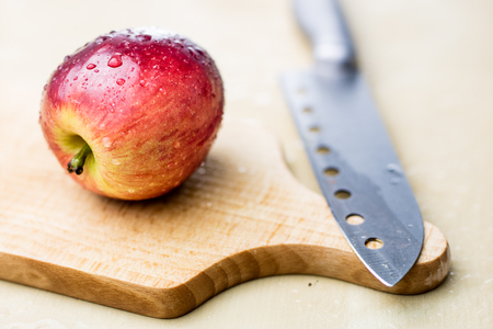 Tasty and ripe apples. Fruit sprinkled with water on a wooden kitchen table. White background.の写真素材