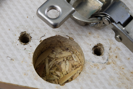 Assembly of hinges in a carpentry workshop. Joinery accessories in a carpentry workshop on a wooden table. Light background.の写真素材