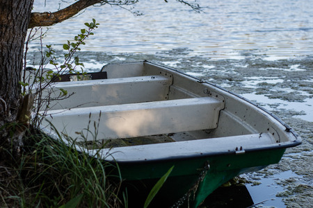 A fishing boat moored to the shore of the lake. Old fishermen's boat prepared for fishing on lakes....