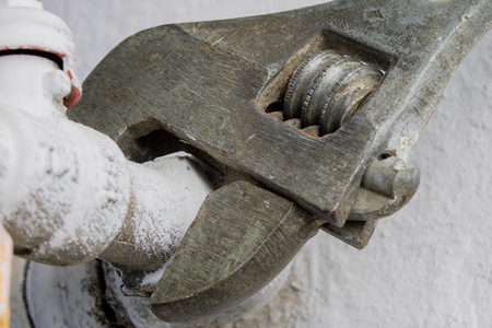 Hydraulic wrench and water installation. Accessories for hydraulics mechanics when repairing old water lines. Dark background.の写真素材