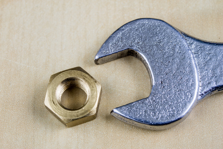 Metric screw and key on a wooden table. Mechanical accessories in the locksmith workshop. Light...