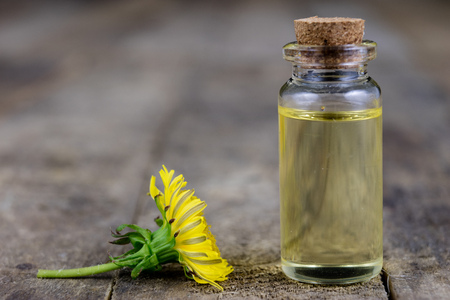 Syrup with dandelion on a wooden table. Cure for colds from natural ingredients. Light background.の写真素材