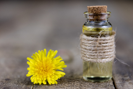 Syrup with dandelion on a wooden table. Cure for colds from natural ingredients. Light background.の写真素材