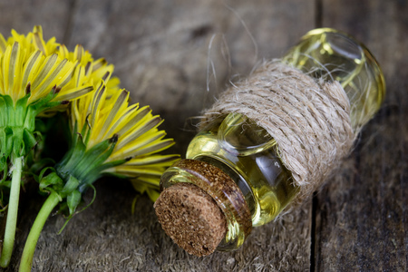 Syrup with dandelion on a wooden table. Cure for colds from natural ingredients. Light background.の写真素材