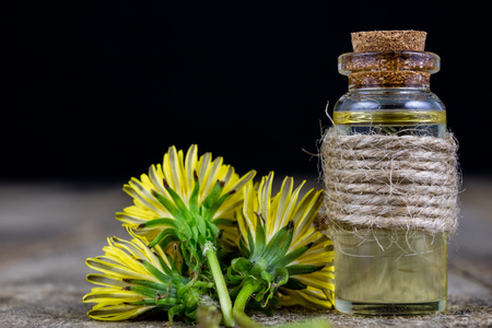 Syrup with dandelion on a wooden table. Cure for colds from natural ingredients. Light background.の写真素材