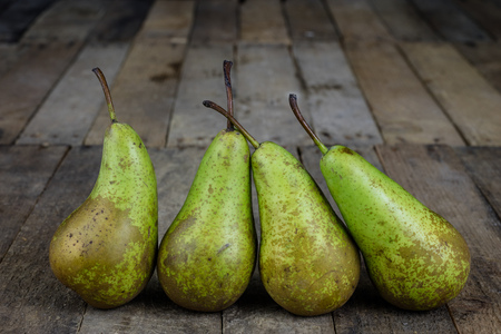 Tasty pears in a jute sack lying on a wooden kitchen table. Fruit for making meals in the kitchen. Dark background.の写真素材