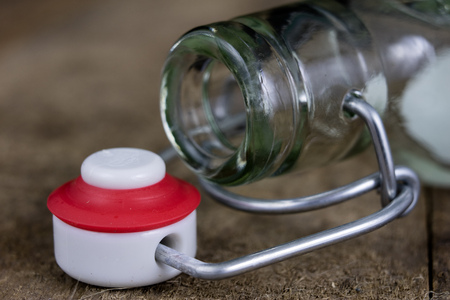 Universal closure of a beverage bottle. Airtight cap closing transparent glass container. Dark...
