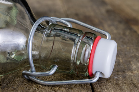 Universal closure of a beverage bottle. Airtight cap closing transparent glass container. Dark background.の写真素材