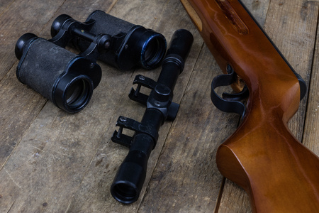 Shooting and pneumatic weapon. Shield and hits with lead bullets on a wooden table. Dark background.