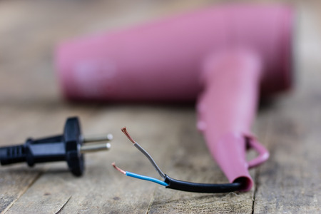 Hair dryer in a hair salon on a wooden table. Hairdressing accessories for hair care. Dark background.の写真素材