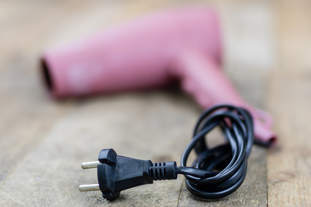 Hair dryer in a hair salon on a wooden table. Hairdressing accessories for hair care. Dark background.の写真素材