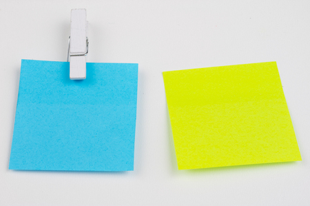 Blank colored sticky notes with clips. Office accessories for listing and memorizing on the table. White background.の写真素材